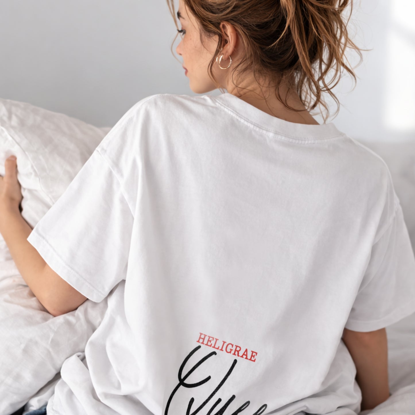 model wearing white t-shirt back queen text heligrae logo